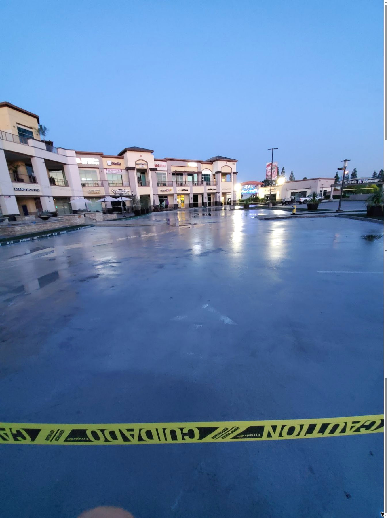 Wet commercial shopping-center common area after pressure washing