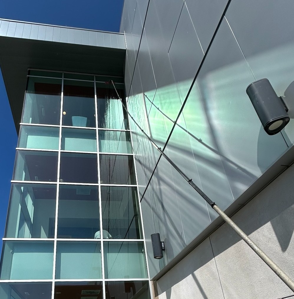 Long-reach cleaning pole being used on exterior glass at a college campus in Huntington Beach.