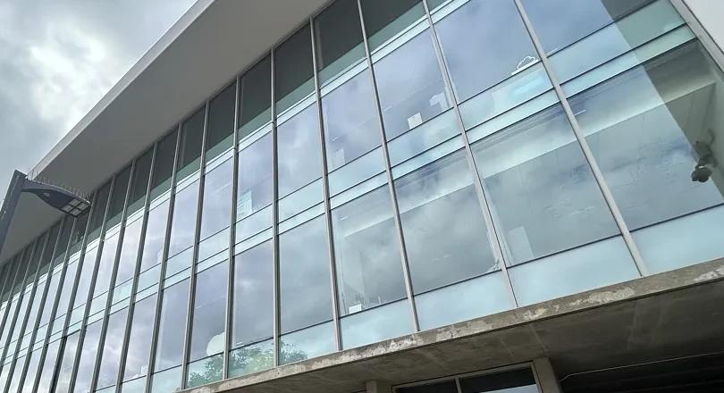 Tall exterior window panels reflecting clouds on a college campus building in Torrance.